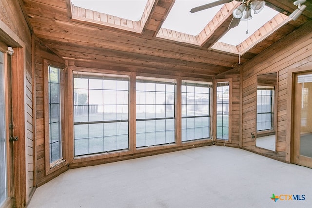 unfurnished sunroom featuring ceiling fan, wood ceiling, and lofted ceiling with skylight