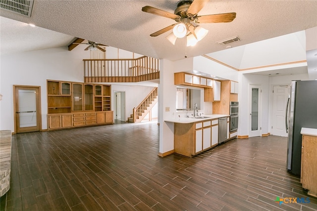 kitchen with stainless steel appliances, a textured ceiling, high vaulted ceiling, dark wood-type flooring, and ceiling fan