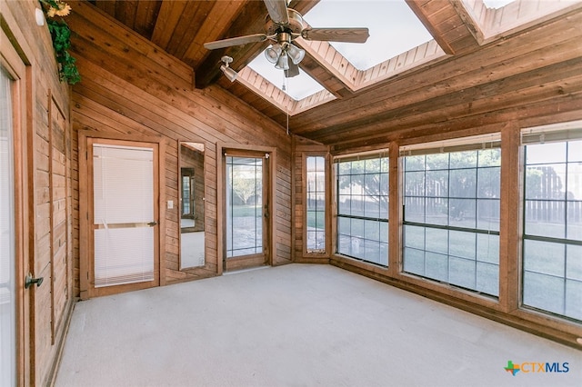 unfurnished sunroom featuring a wealth of natural light, ceiling fan, lofted ceiling with skylight, and wooden ceiling