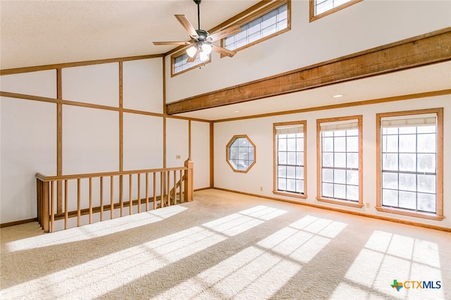 interior space with a towering ceiling, ceiling fan, plenty of natural light, and light carpet