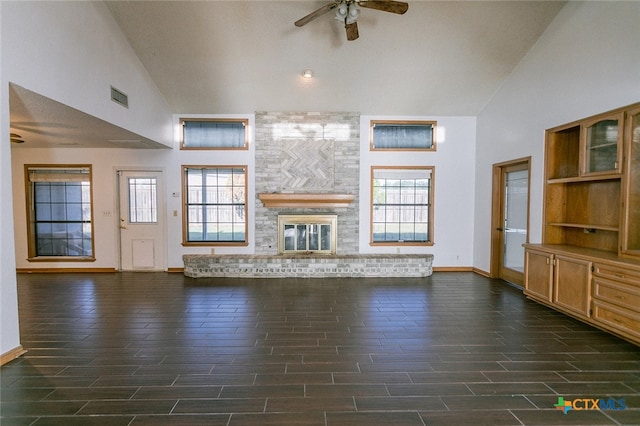 unfurnished living room with high vaulted ceiling, dark wood-type flooring, ceiling fan, and a fireplace