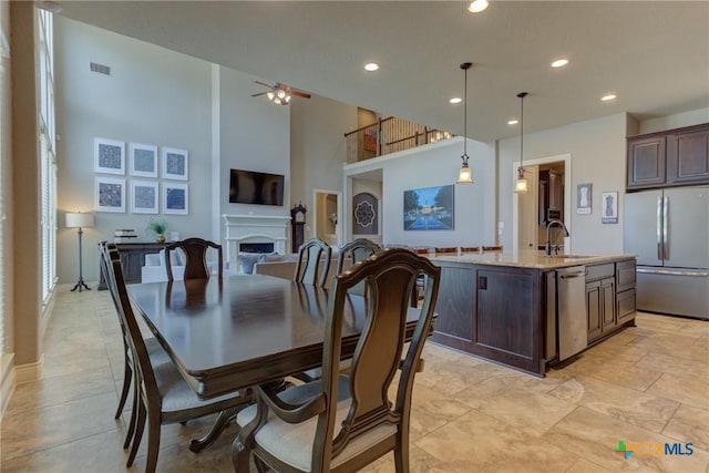 2326 Haven Bluff Ct, New Braunfels, TX 78132 - dining area with ceiling fan, a fireplace, recessed lighting, a towering ceiling, and baseboards