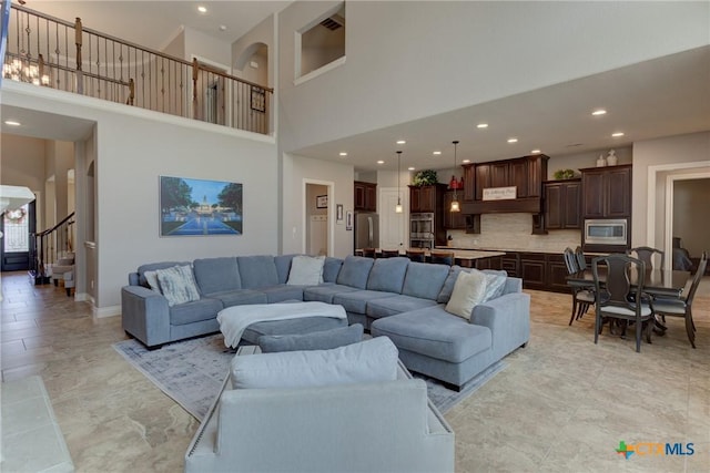 2326 Haven Bluff Ct, New Braunfels, TX 78132 - living area with a towering ceiling, recessed lighting, stairs, baseboards, and arched walkways