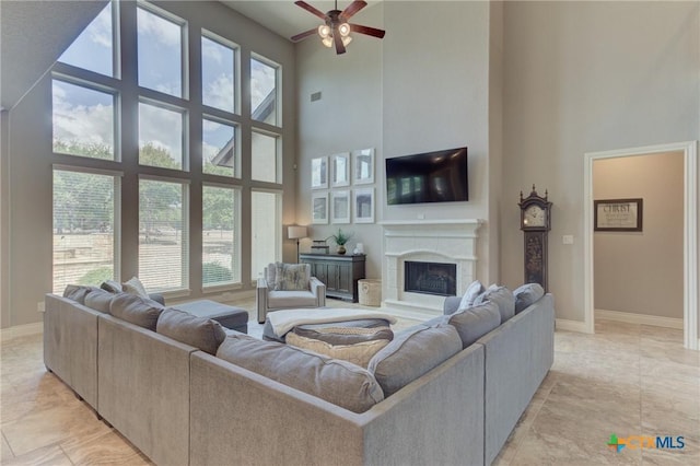 2326 Haven Bluff Ct, New Braunfels, TX 78132 - living area featuring a towering ceiling, a ceiling fan, a high end fireplace, and baseboards