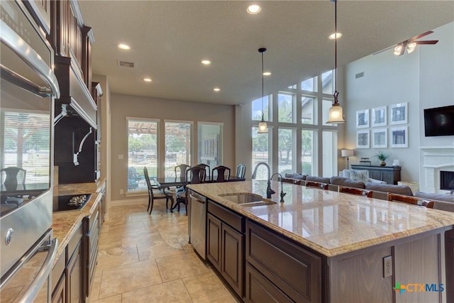 2326 Haven Bluff Ct, New Braunfels, TX 78132 - kitchen with a sink, stainless steel appliances, a kitchen island with sink, recessed lighting, and light stone counters