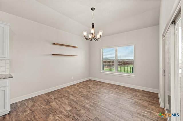 6119 Big Tree Dr, Salado, TX 76571 - empty room with a chandelier, wood finished floors, and baseboards