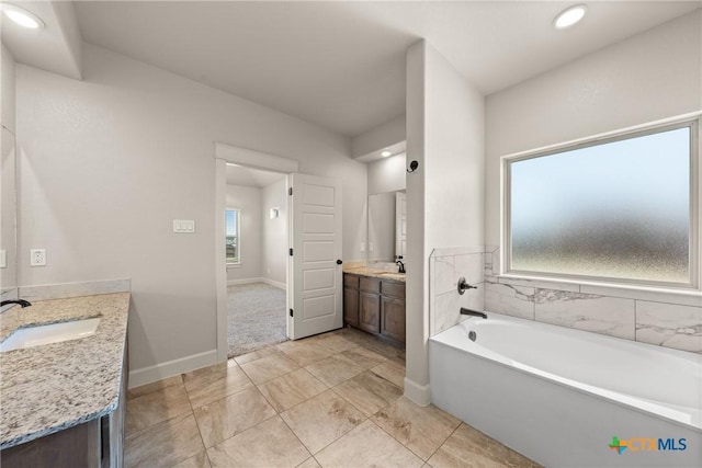 6119 Big Tree Dr, Salado, TX 76571 - full bath featuring two vanities, a garden tub, recessed lighting, and baseboards