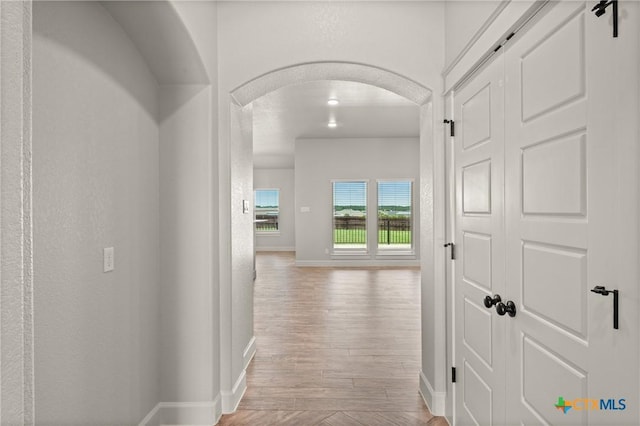 6119 Big Tree Dr, Salado, TX 76571 - hall featuring arched walkways, light wood-style flooring, and baseboards