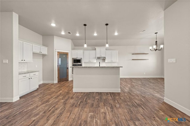6119 Big Tree Dr, Salado, TX 76571 - kitchen with stainless steel microwave, backsplash, white cabinets, dark wood finished floors, and recessed lighting
