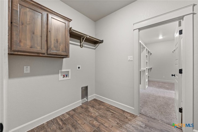 6119 Big Tree Dr, Salado, TX 76571 - laundry area with cabinet space, electric dryer hookup, dark wood-style flooring, washer hookup, and baseboards