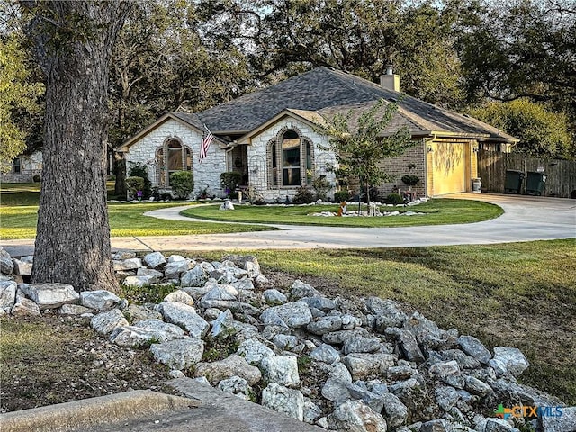 view of front facade featuring a shingled roof, a front lawn, a chimney, stone siding, and driveway