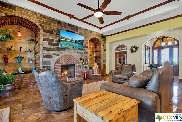 living room featuring brick wall, ceiling fan, and a fireplace