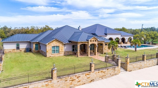 view of front of home with central AC unit, a front lawn, a patio, and a fenced in pool