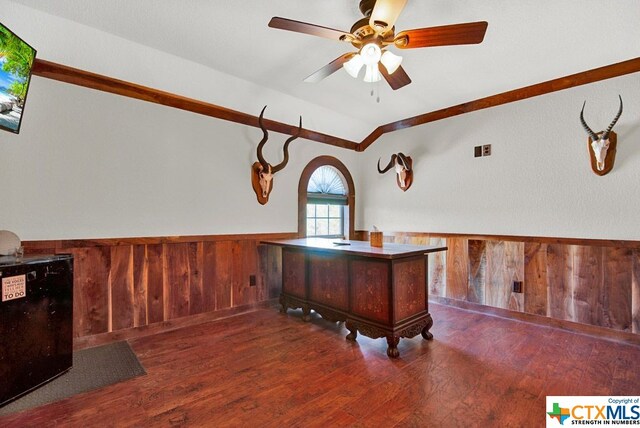 office area with ceiling fan, wooden walls, and dark hardwood / wood-style flooring