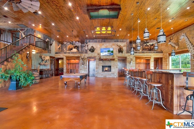 interior space with a high ceiling, pool table, wood ceiling, and hanging light fixtures