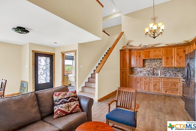 interior space with sink, light hardwood / wood-style flooring, and a notable chandelier