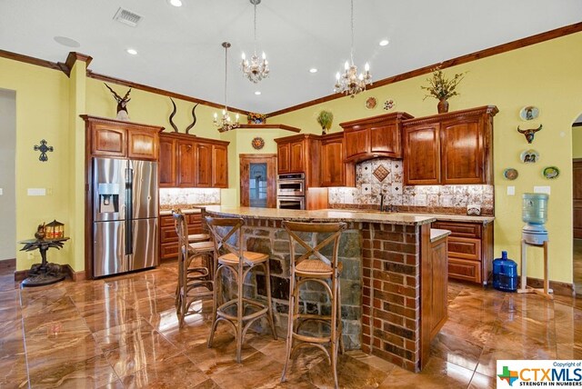 kitchen with ornamental molding, decorative backsplash, appliances with stainless steel finishes, and a kitchen island