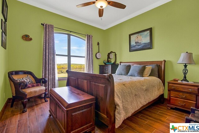 bedroom featuring dark wood-type flooring, ceiling fan, and crown molding