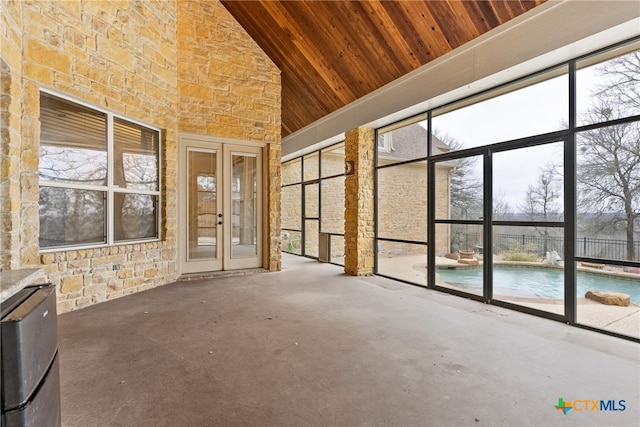 unfurnished sunroom with wood ceiling, lofted ceiling, and french doors