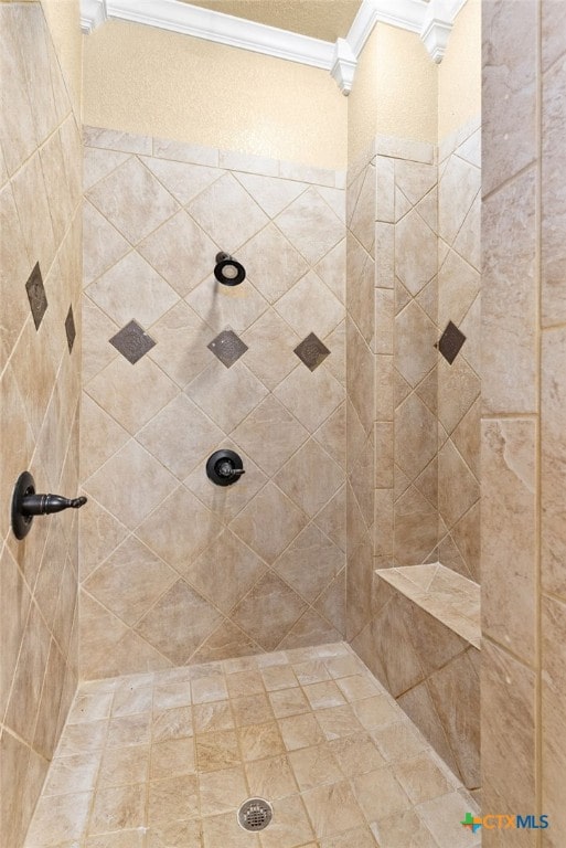 bathroom with ornate columns, tiled shower, and crown molding