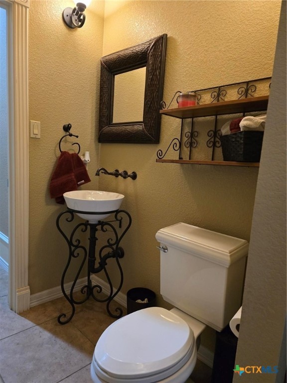 bathroom featuring toilet, sink, and tile patterned floors