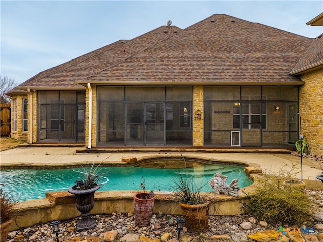 pool with a sunroom and a patio