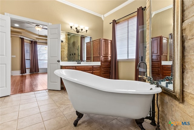 bathroom featuring ornamental molding, tile patterned flooring, a soaking tub, and a sink
