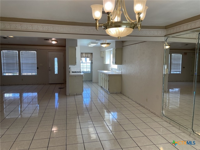 307 Hickok Ct, Austin, TX 78753 - kitchen with light tile patterned floors, a chandelier, a sink, light countertops, and ornamental molding