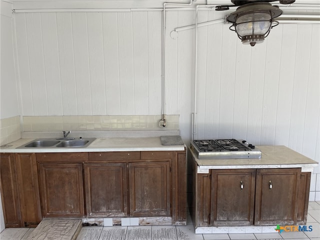 307 Hickok Ct, Austin, TX 78753 - kitchen with a sink, light countertops, stainless steel gas cooktop, and wood walls