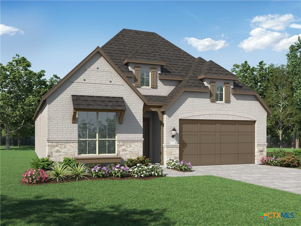 view of front of home with a garage and a front lawn