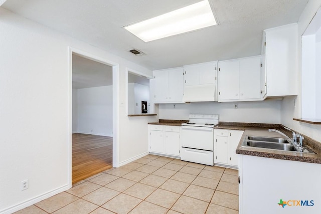 1488 Canyon Edge, Canyon Lake, TX 78133 - kitchen featuring white electric range oven, a sink, custom range hood, dark countertops, and white cabinets