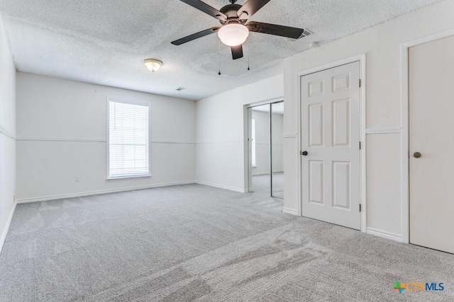 1488 Canyon Edge, Canyon Lake, TX 78133 - unfurnished bedroom with a textured ceiling, carpet, baseboards, a closet, and ceiling fan