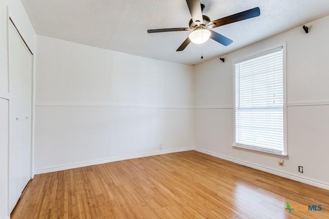 1488 Canyon Edge, Canyon Lake, TX 78133 - spare room with light wood-style flooring, a ceiling fan, healthy amount of natural light, a textured ceiling, and baseboards