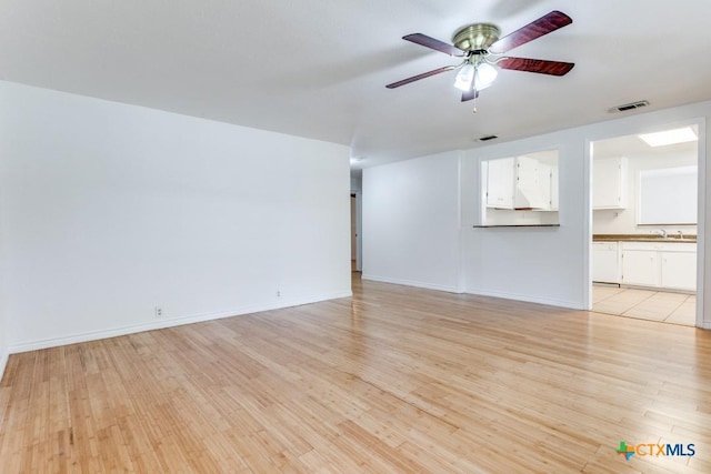 1488 Canyon Edge, Canyon Lake, TX 78133 - unfurnished living room with light wood-style floors, a sink, ceiling fan, and baseboards
