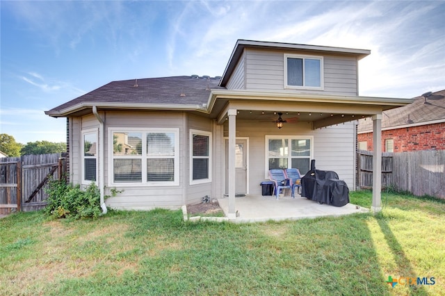 back of property with a lawn, ceiling fan, and a patio