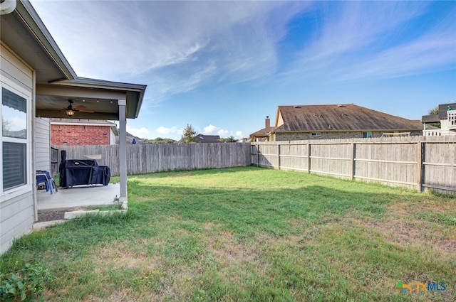 view of yard with ceiling fan and a patio area