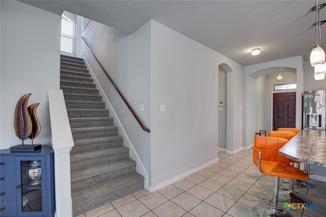 interior space with a textured ceiling and tile patterned floors