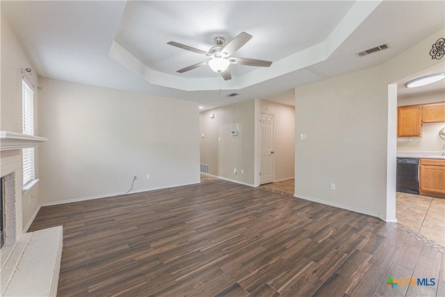 2405 Thoroughbred Dr, Killeen, TX 76549 - unfurnished living room featuring a ceiling fan, wood finished floors, a fireplace, visible vents, and a raised ceiling