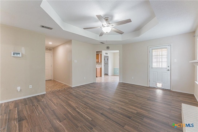 2405 Thoroughbred Dr, Killeen, TX 76549 - unfurnished living room featuring ceiling fan, wood finished floors, visible vents, and a raised ceiling