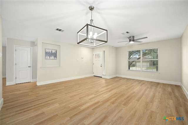 interior space featuring ceiling fan with notable chandelier and light hardwood / wood-style flooring