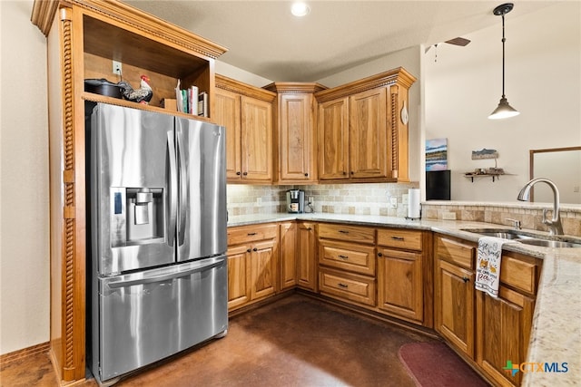 kitchen with light stone counters, stainless steel fridge with ice dispenser, a sink, decorative backsplash, and pendant lighting