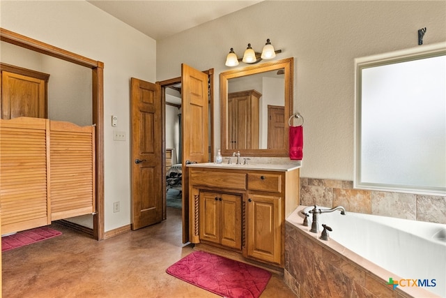 full bath featuring a bath, vanity, and baseboards