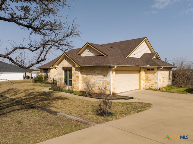 view of front of house featuring concrete driveway, an attached garage, and a shingled roof