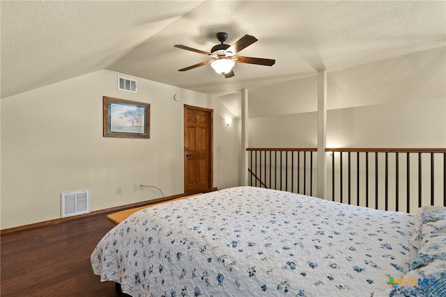 bedroom with visible vents, a textured ceiling, lofted ceiling, and wood finished floors