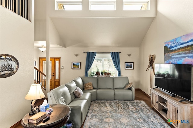 living area featuring high vaulted ceiling and stairs