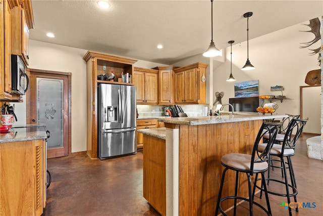 kitchen featuring stainless steel fridge, backsplash, a peninsula, and finished concrete flooring