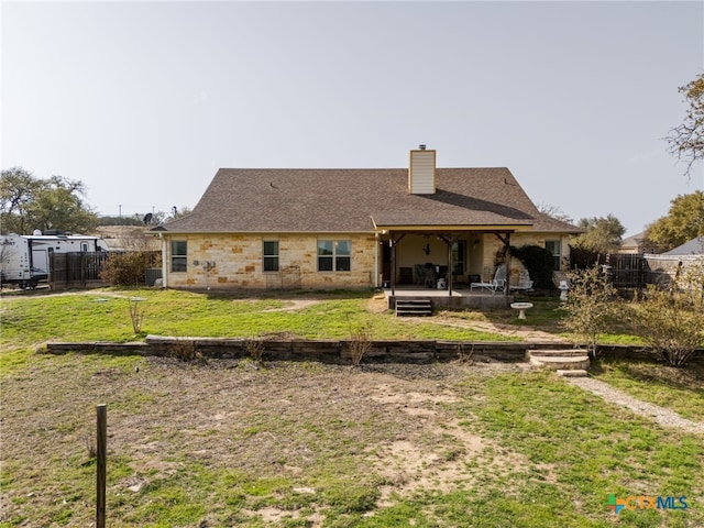 rear view of property with a patio area, fence, a lawn, and a chimney