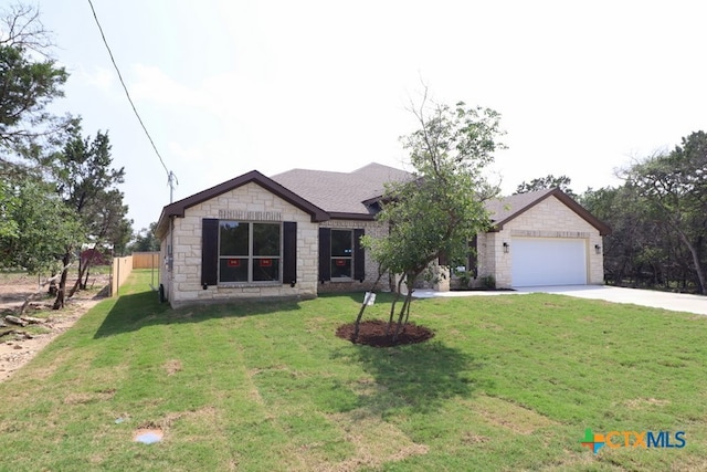 single story home with a garage and a front lawn