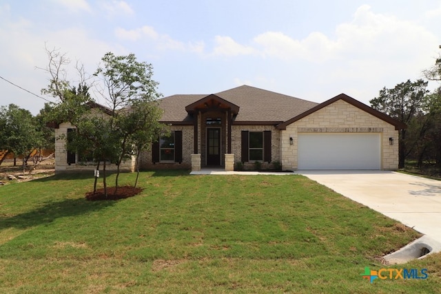 view of front of property featuring a front yard and a garage