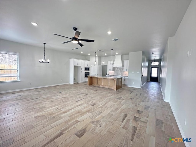 kitchen featuring open floor plan, premium range hood, a wealth of natural light, and visible vents